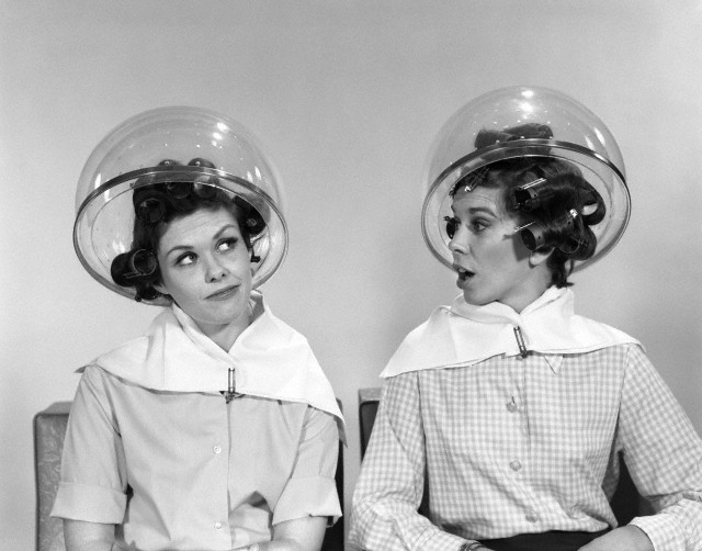 1960s two women sitting under hairdryers gossiping